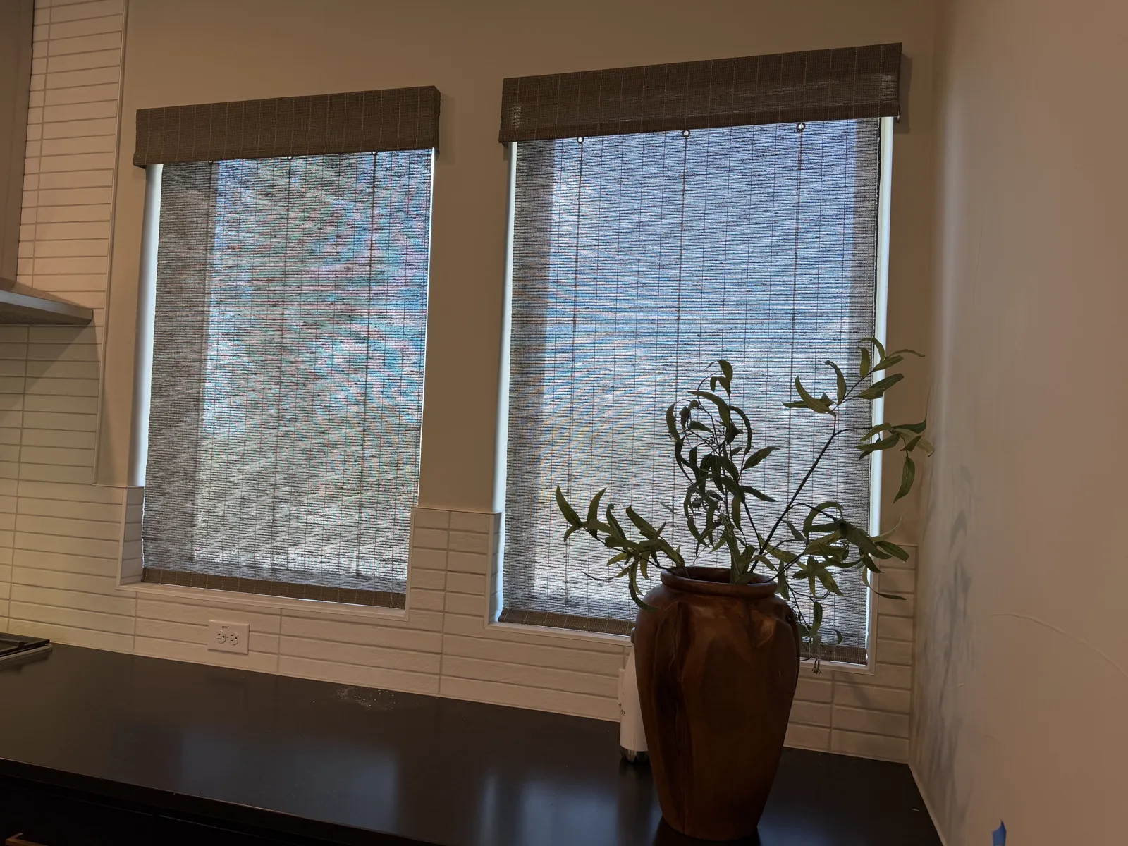 Woven wood shades over kitchen windows with natural texture