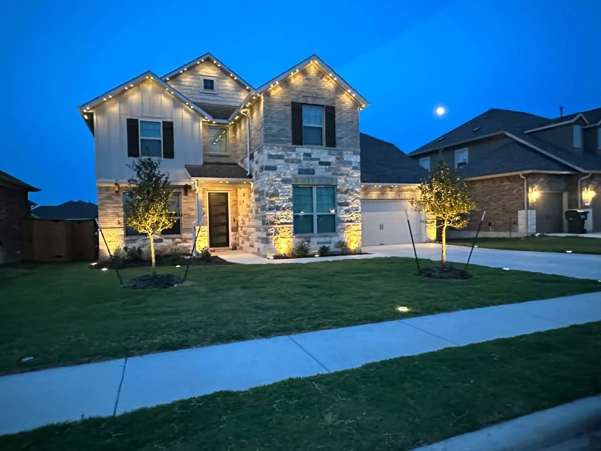 Texas home at dusk with warm permanent lighting tracing the roofline
