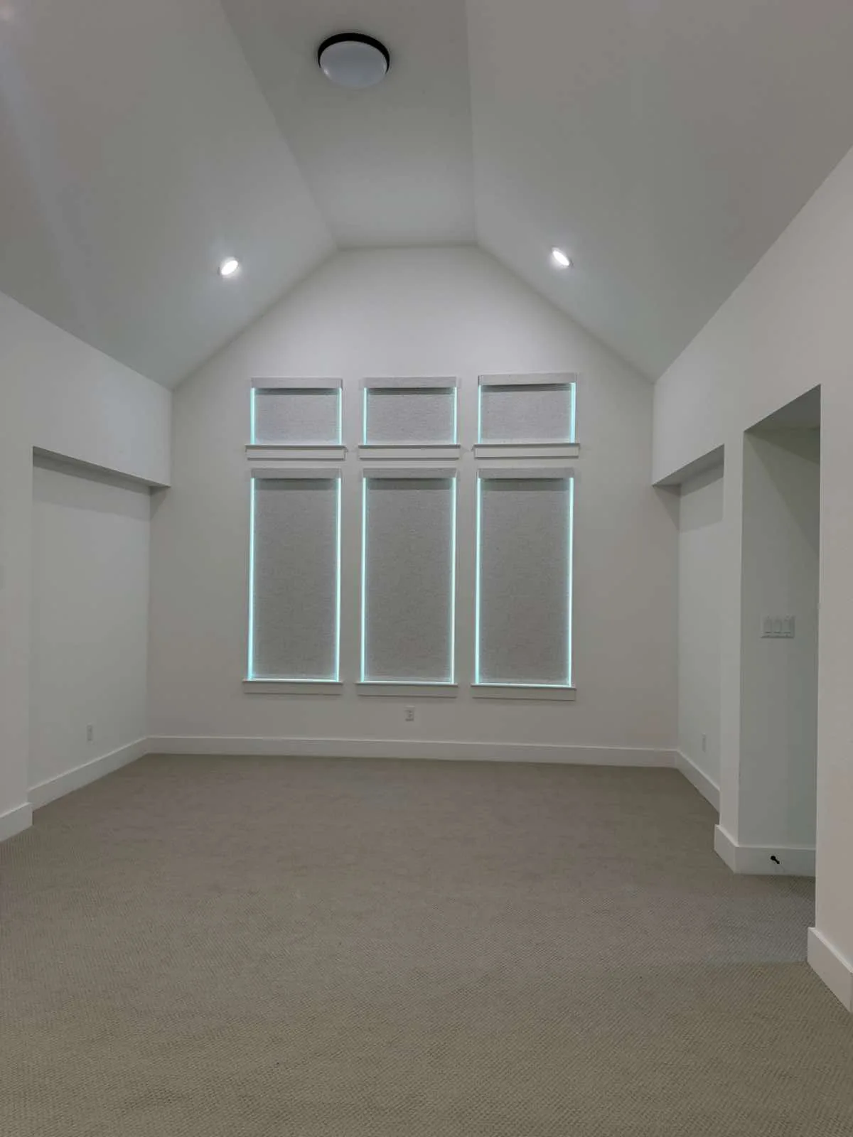 Room with tall stacked windows fitted with clean white interior shutters