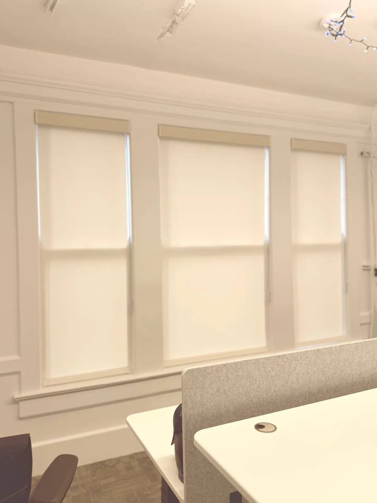 Cellular shades installed on three windows in a light-filled room