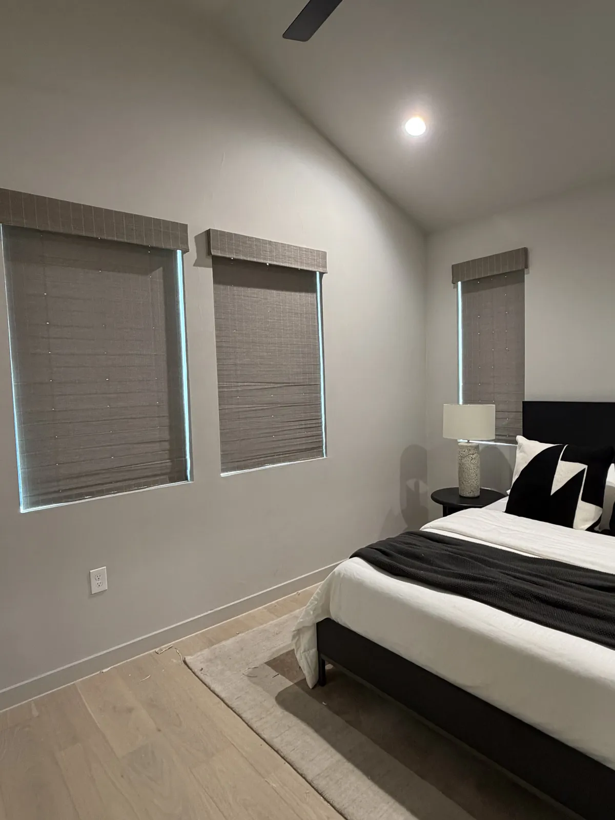 Bedroom with soft fabric shades framing the bed